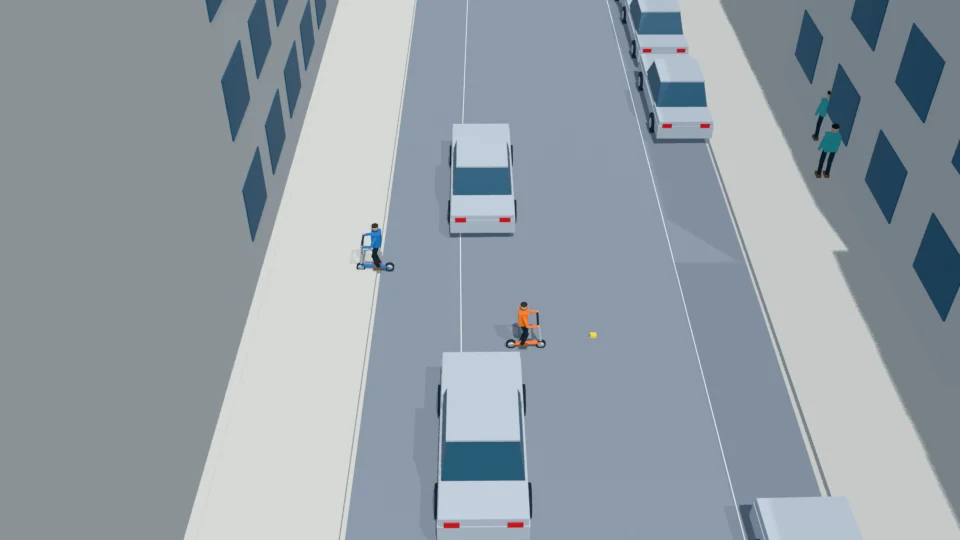 The stopped child finishes a manual scooter pivot toward the dropped box.